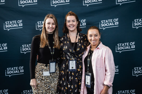 Three delegates in front of the State of Social backdrop, State of Social ’19