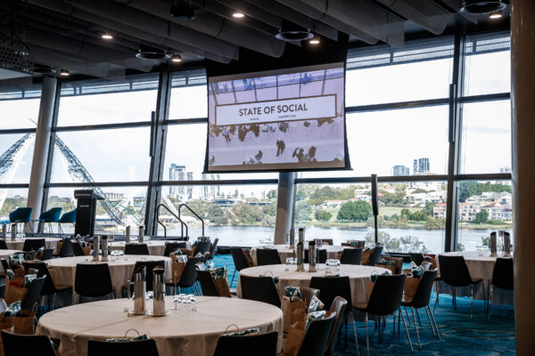 Round tables set in the function room with the river outside, State of Social ’18