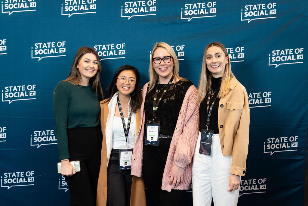 Four delegates pose in front of the State of Social backdrop, State of Social ’21
