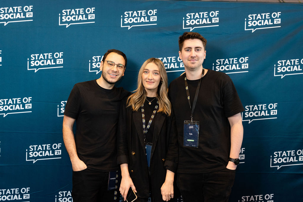 Three delegates pose in front of the State of Social backdrop, State of Social ’21