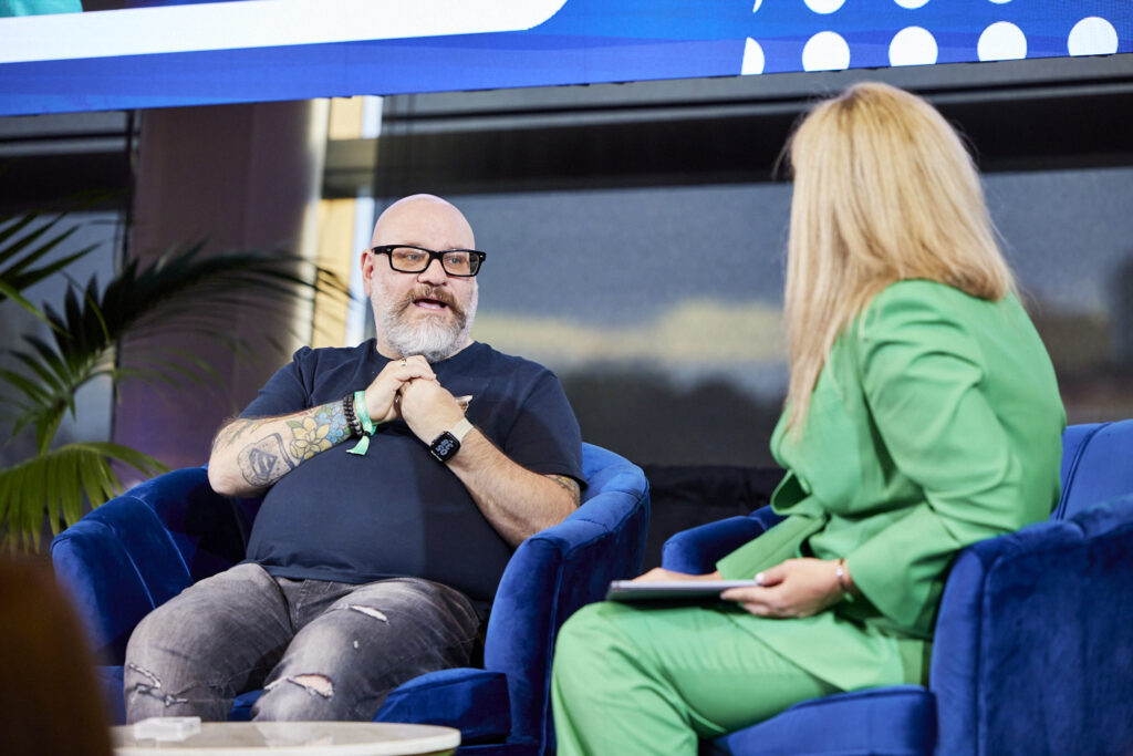 Man and woman in armchairs on stage in a fireside conversation, State of Social ’23