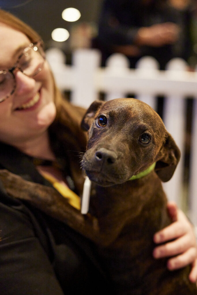 Delegate cuddles a small brown dog, State of Social ’23