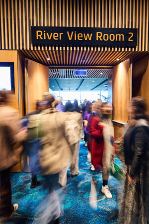 Delegates walk the corridor to River View Room 2, State of Social ’25
