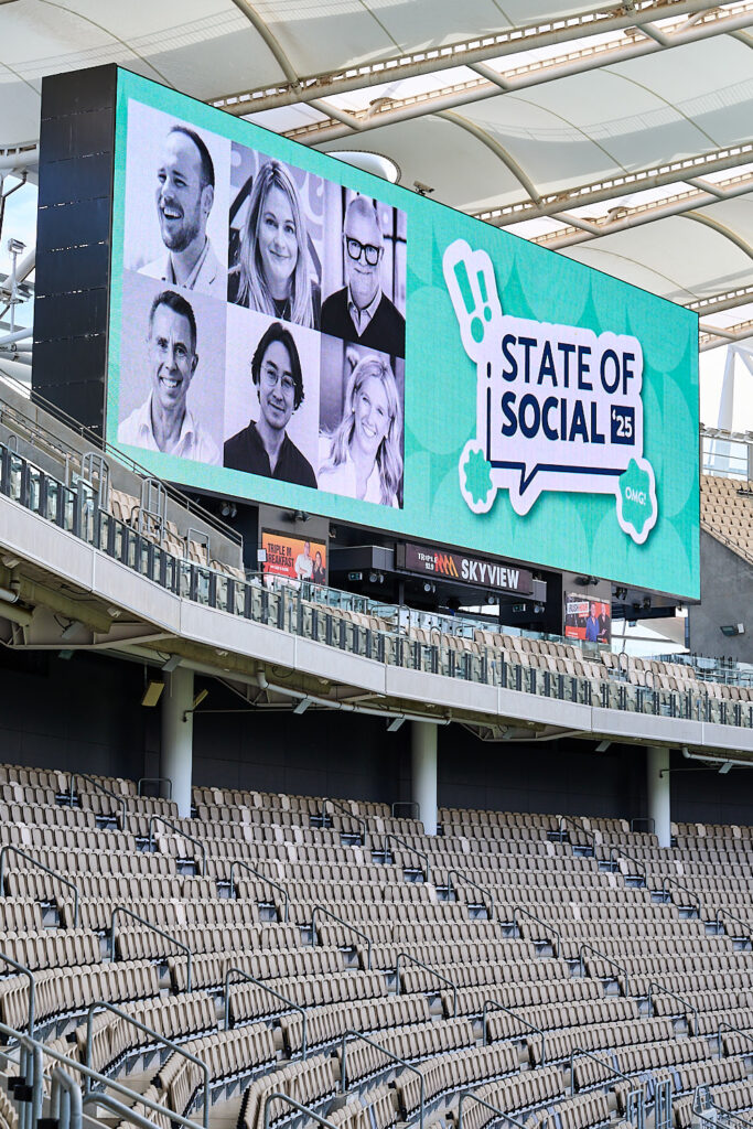 Stadium screen showing speaker portraits and the State of Social ’25 logo, State of Social ’25