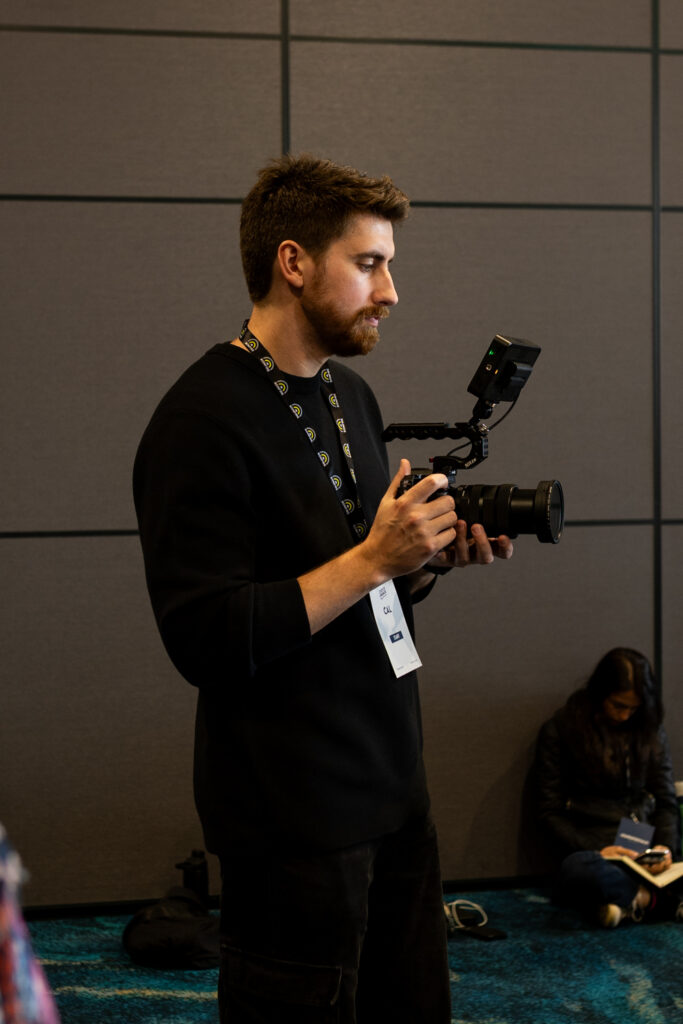 Videographer in black holds a camera during the event, State of Social ’25