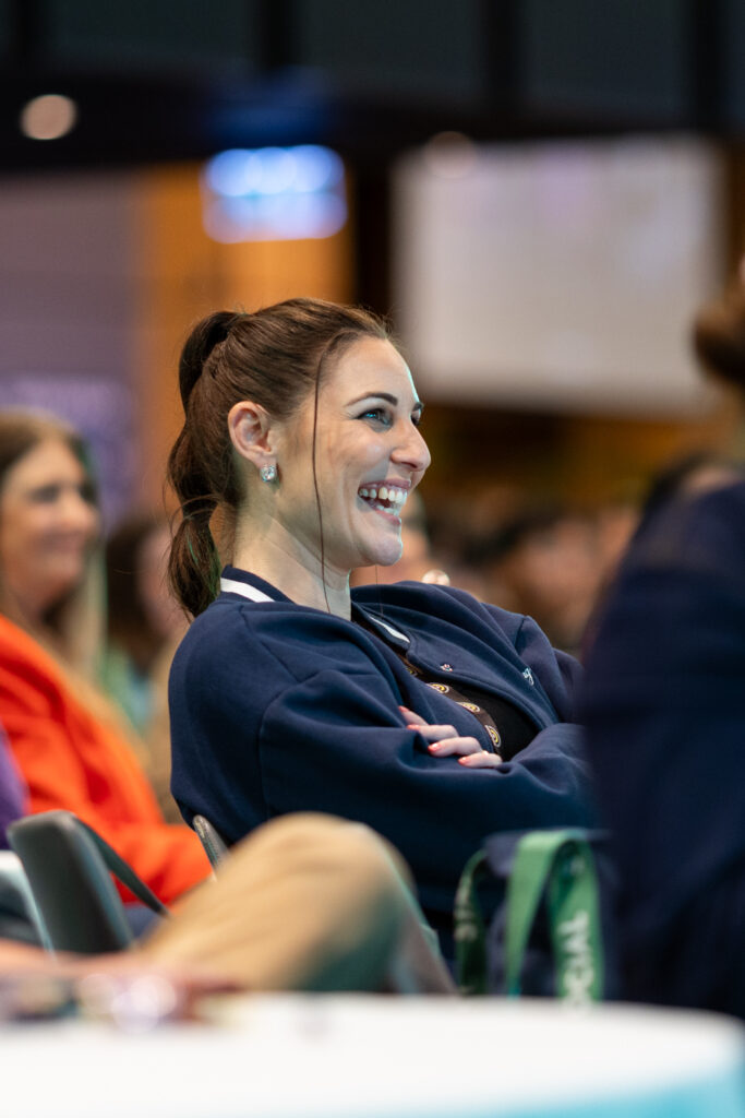 Delegate in a navy top smiles as she listens, State of Social ’25