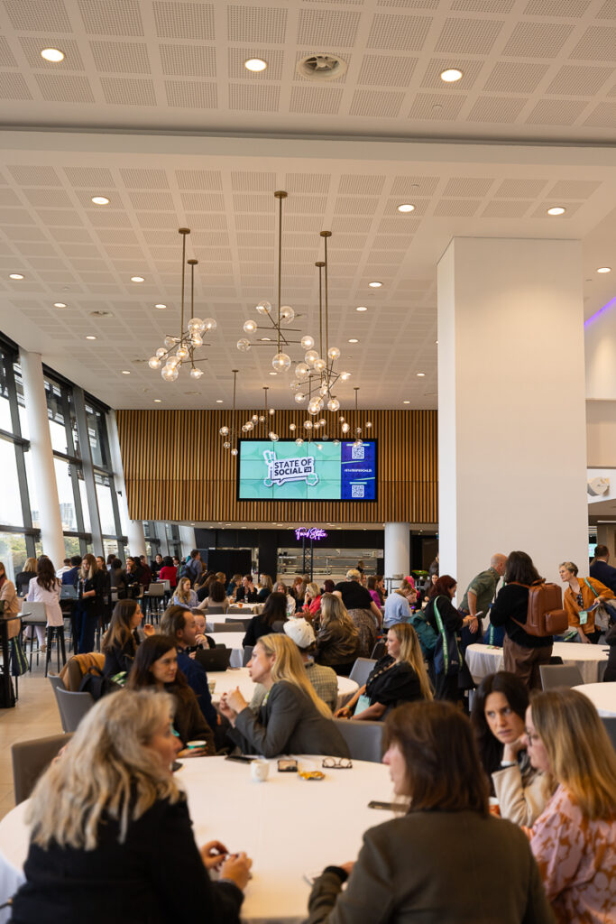 Delegates at tables in the foyer under pendant lights
