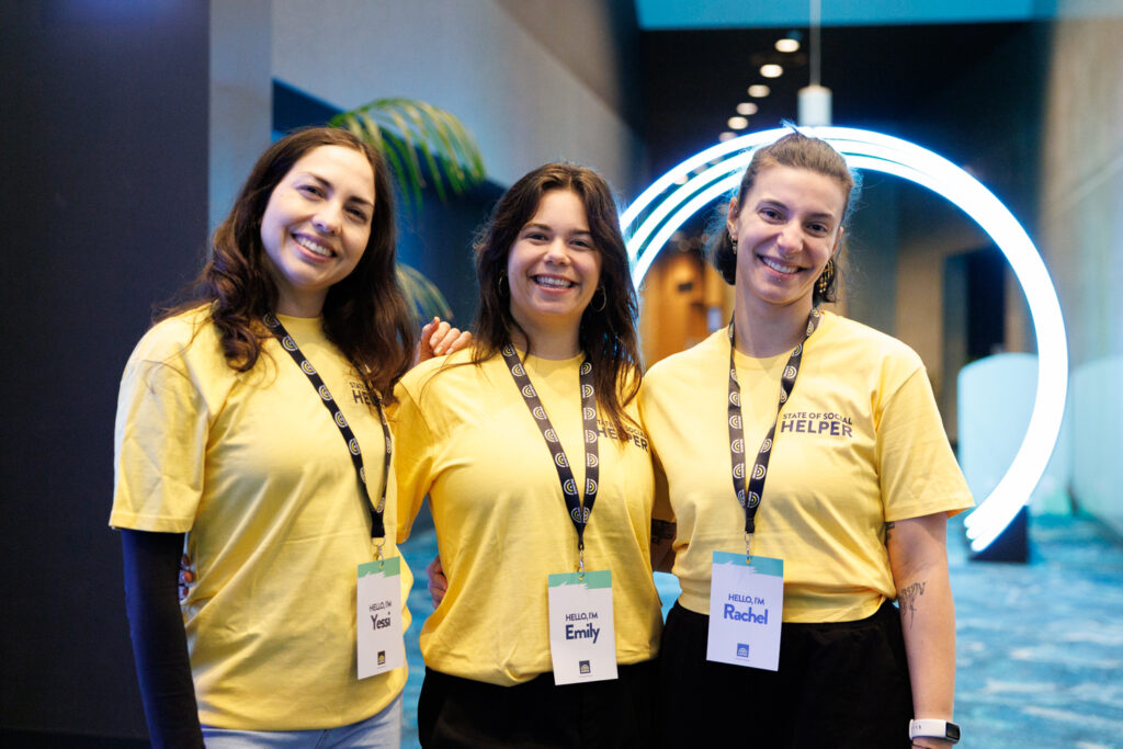 Three volunteers in yellow t-shirts pose together, State of Social ’26