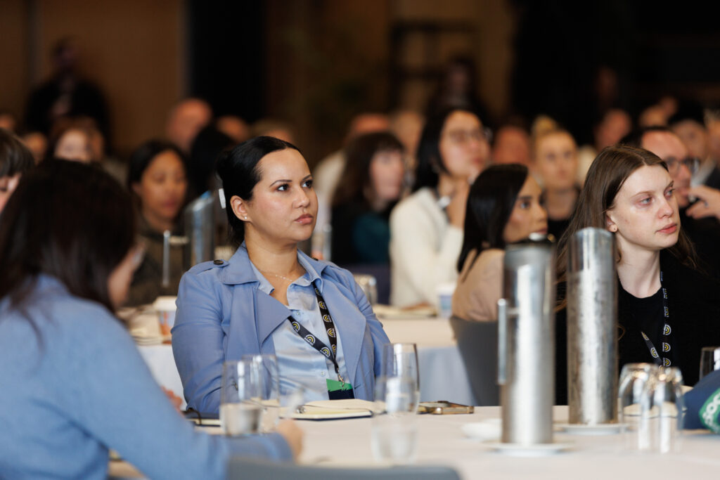 Delegate smiles at a crowded table during a session, State of Social ’26