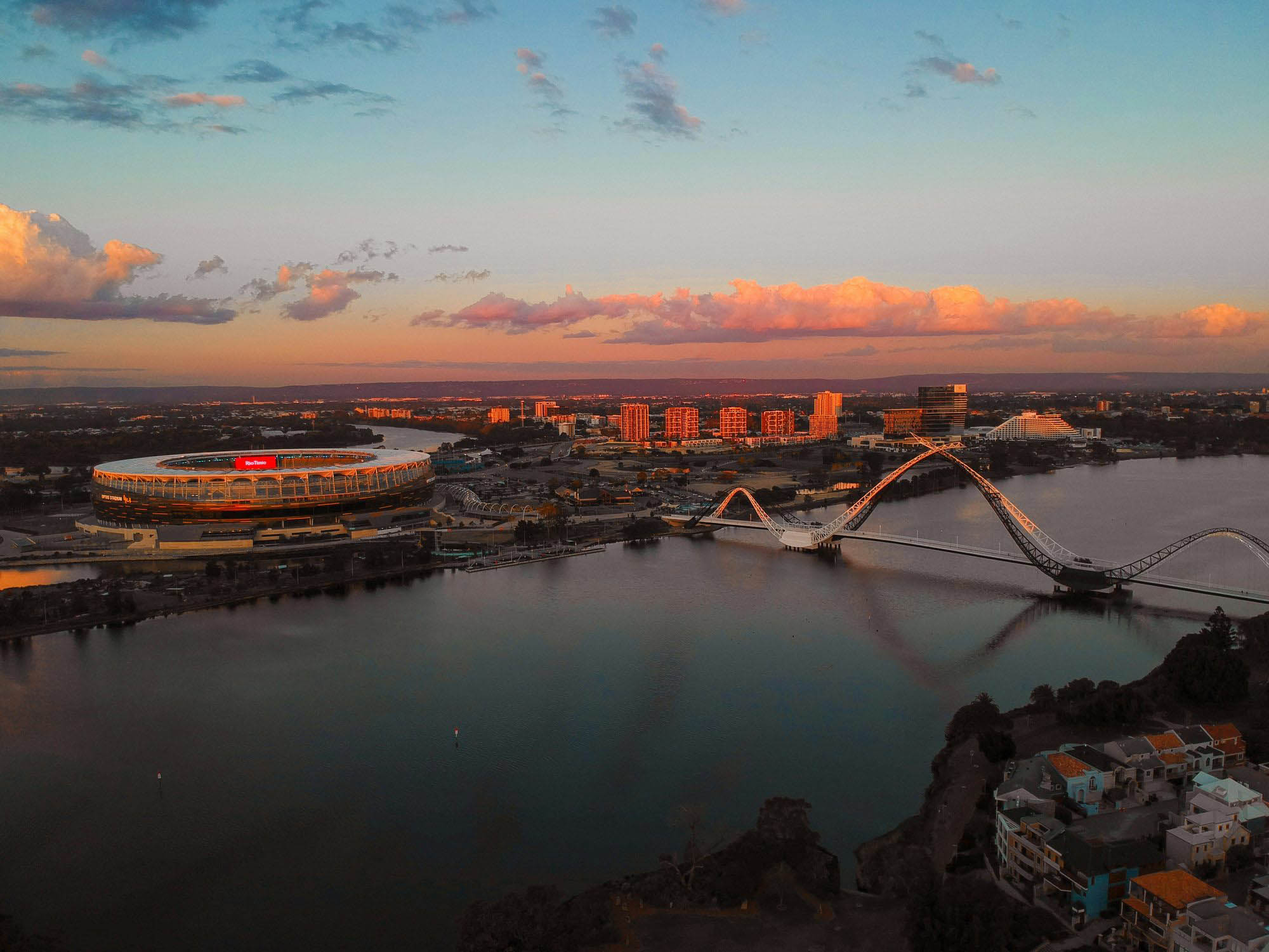 The Perth skyline and Optus Stadium across the river at dusk
