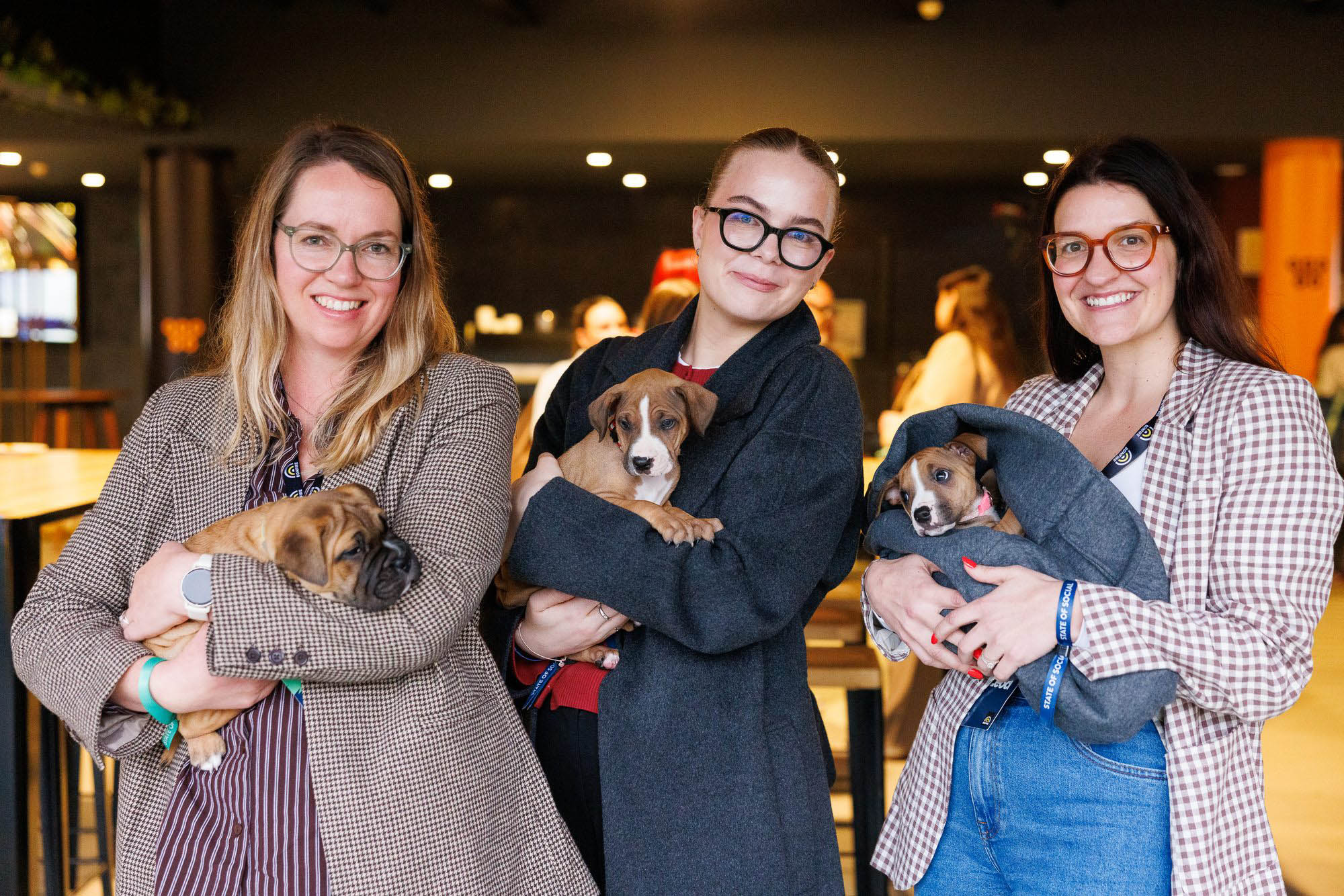 Three delegates each holding a puppy